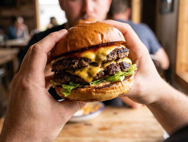 Juicy burger holding on hand